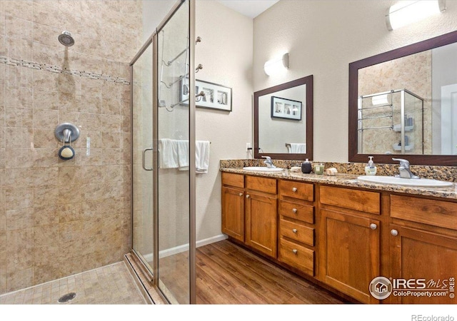 bathroom featuring vanity, wood-type flooring, and a shower with door