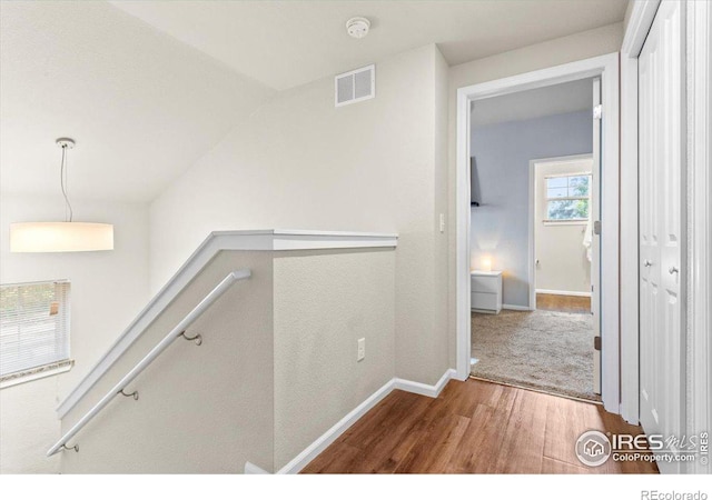 hall with hardwood / wood-style floors and vaulted ceiling