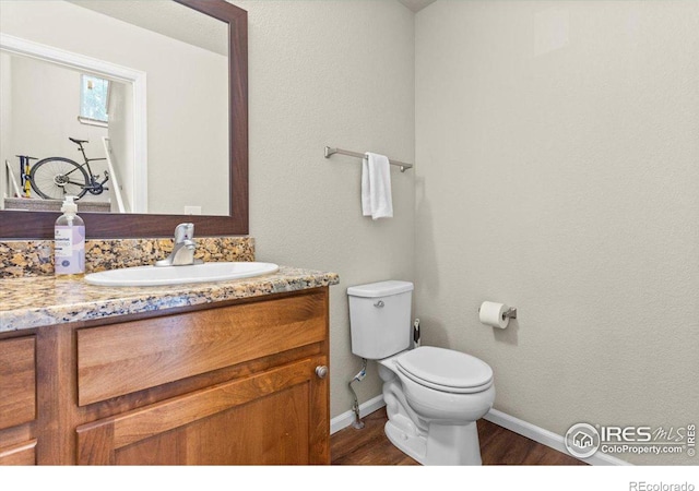 bathroom featuring vanity, hardwood / wood-style flooring, and toilet