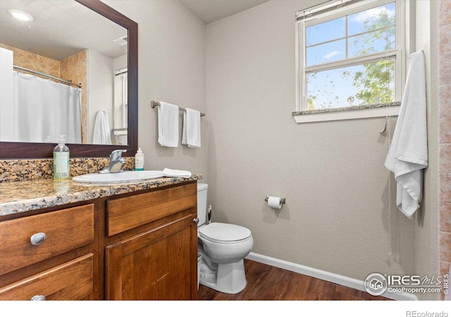 bathroom featuring a shower with curtain, vanity, hardwood / wood-style flooring, and toilet