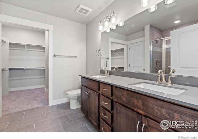 bathroom with tile patterned floors, toilet, vanity, and walk in shower