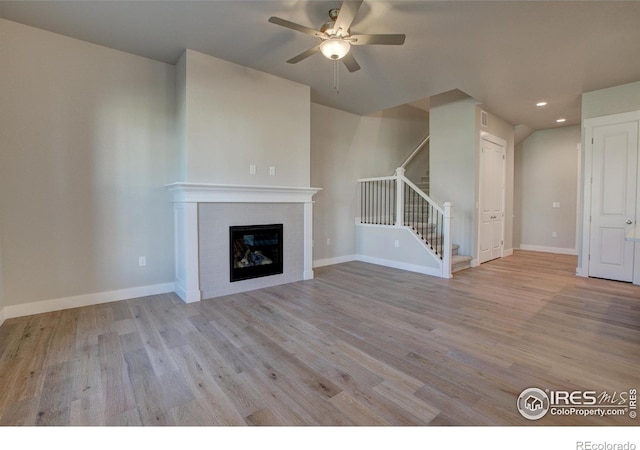 unfurnished living room featuring ceiling fan and light hardwood / wood-style flooring