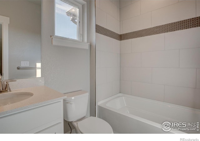 full bathroom with tiled shower / bath, oversized vanity, and toilet