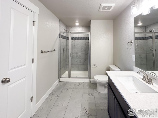 bathroom with vanity, toilet, and a shower with shower door