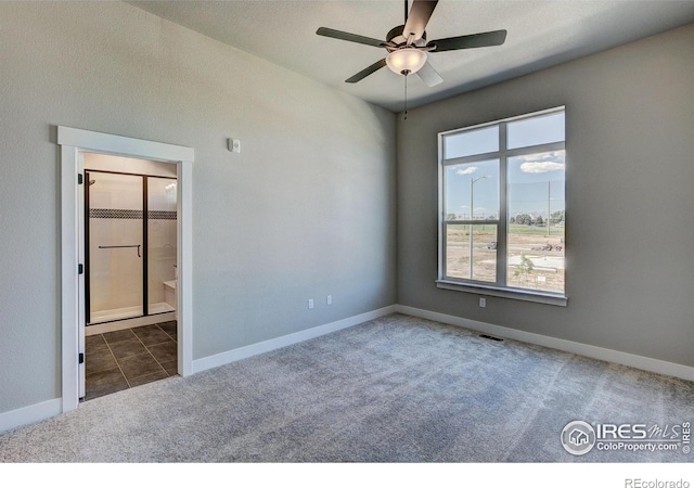 unfurnished room with ceiling fan and dark carpet