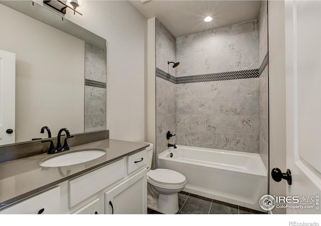 full bathroom with tile patterned floors, vanity, tiled shower / bath combo, and toilet