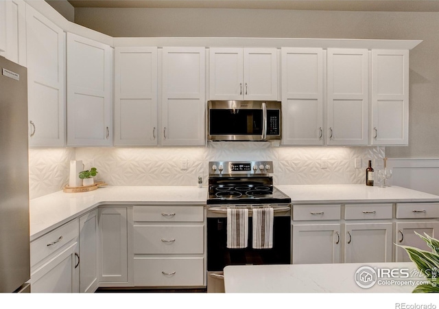 kitchen with tasteful backsplash, white cabinets, and stainless steel appliances