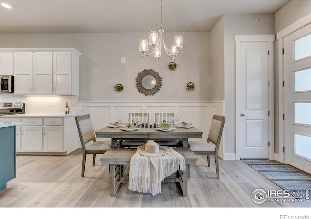 dining space featuring light hardwood / wood-style flooring, plenty of natural light, and a notable chandelier