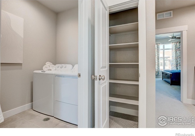 laundry room featuring ceiling fan, light carpet, and washing machine and clothes dryer