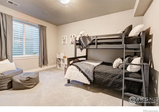 bedroom featuring carpet flooring and a textured ceiling