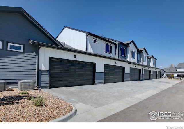 exterior space with central AC unit and a garage