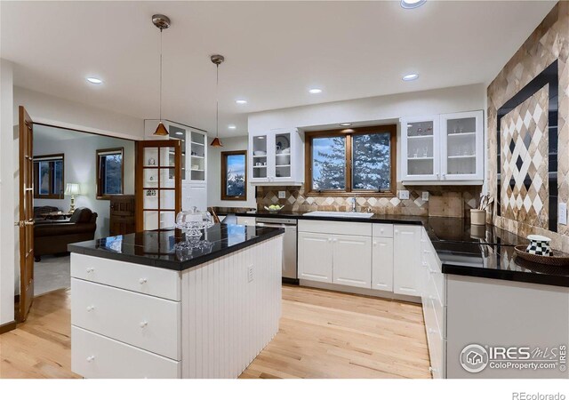 kitchen with a kitchen island, dishwasher, light hardwood / wood-style floors, white cabinetry, and hanging light fixtures