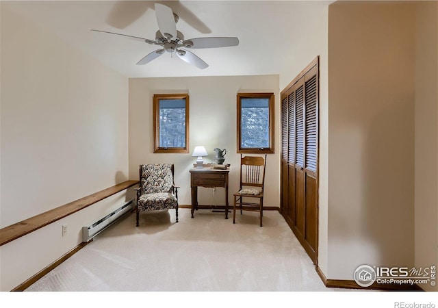 living area featuring baseboard heating, ceiling fan, and light colored carpet