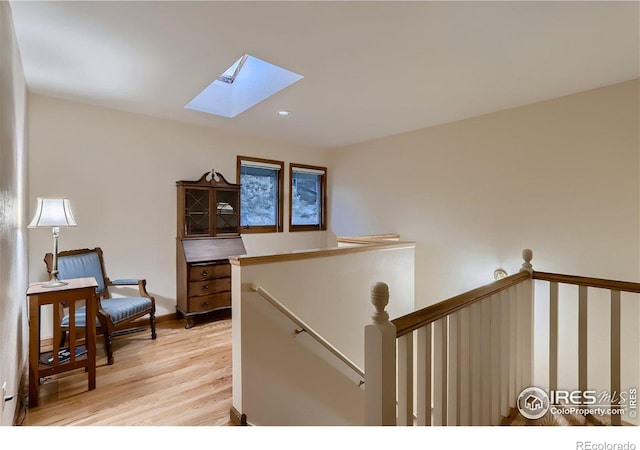 interior space featuring a skylight and light hardwood / wood-style floors