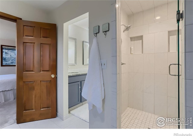 bathroom with tile patterned flooring, vanity, and walk in shower