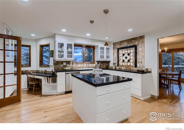 kitchen featuring a center island, hanging light fixtures, stainless steel dishwasher, light hardwood / wood-style floors, and white cabinetry