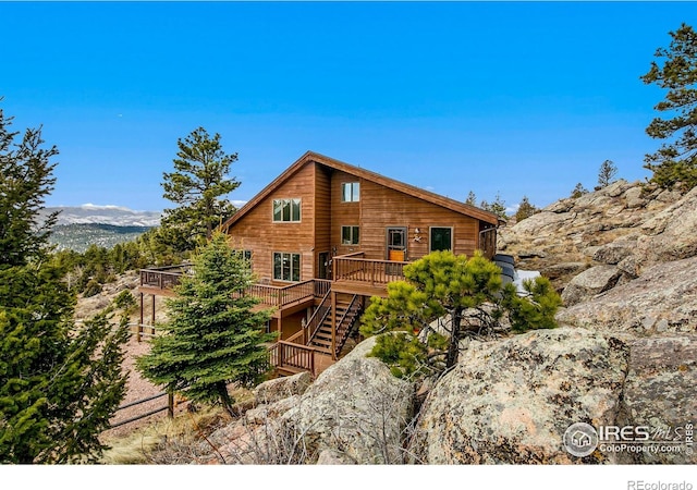 rear view of house with a deck with mountain view