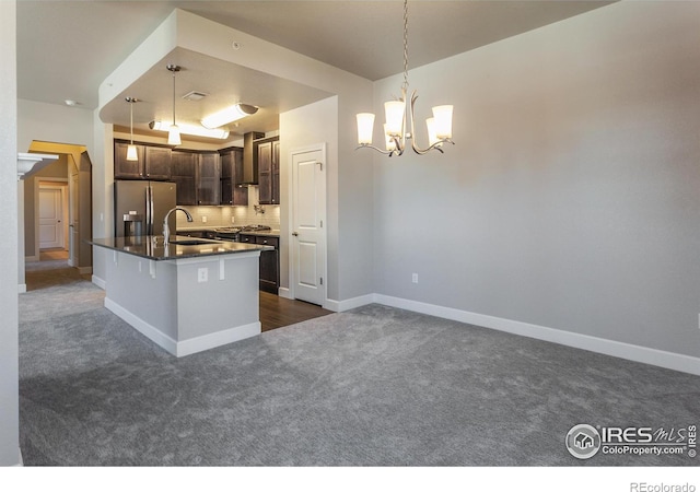 kitchen with stainless steel refrigerator with ice dispenser, dark carpet, dark brown cabinetry, sink, and decorative light fixtures