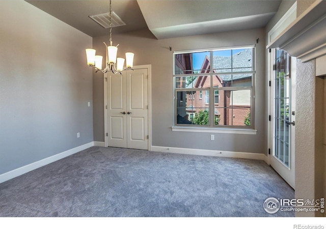 carpeted empty room with a notable chandelier