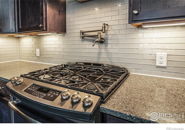 kitchen featuring gas stove, stone counters, and decorative backsplash