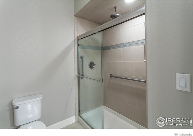 bathroom featuring toilet and an enclosed shower