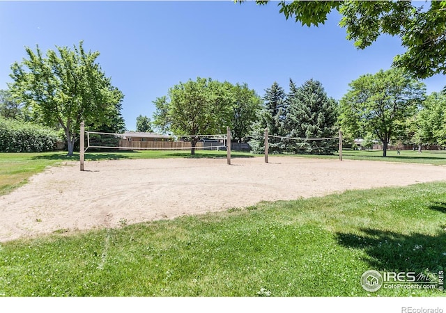 view of property's community with a lawn and volleyball court