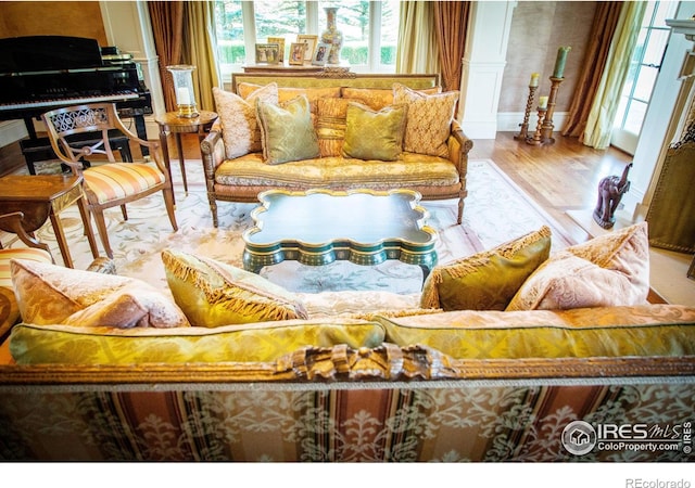 living room with light wood-type flooring and ornate columns