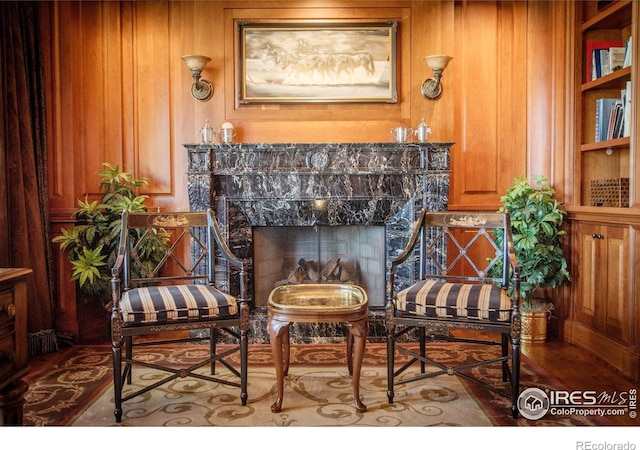 living area with built in features and wood walls