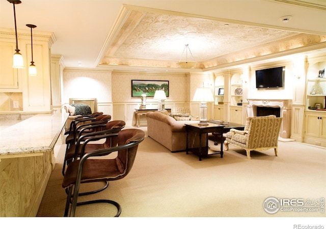 living room featuring ornamental molding, a raised ceiling, light colored carpet, and built in features