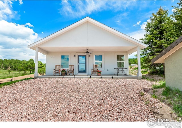 rear view of house featuring ceiling fan and covered porch