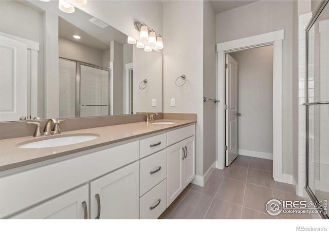 bathroom with tile patterned flooring, a shower with shower door, and vanity