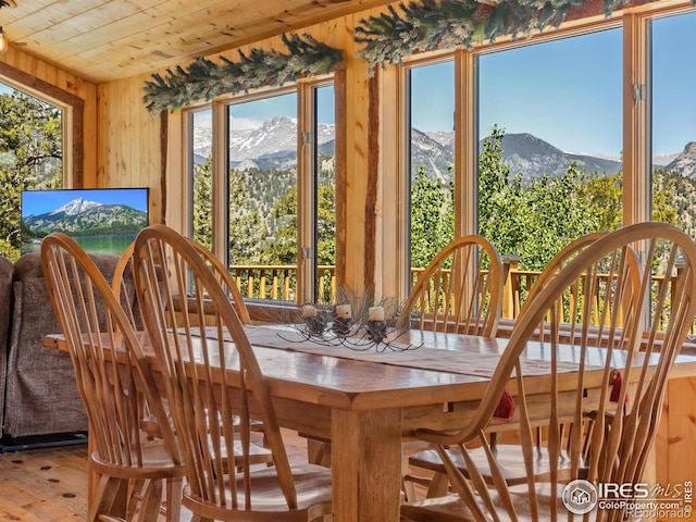 sunroom featuring a chandelier, wooden ceiling, and a mountain view