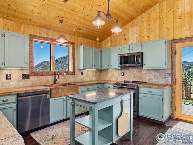 kitchen featuring wooden ceiling, stainless steel appliances, dark wood-type flooring, a mountain view, and decorative light fixtures