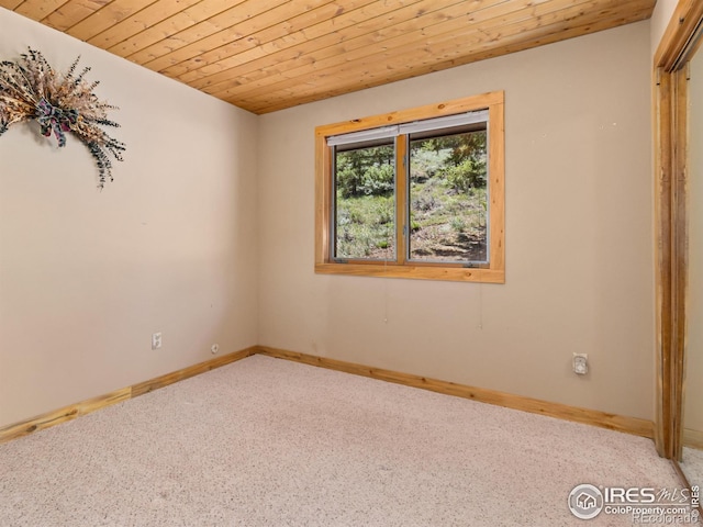 carpeted empty room with wooden ceiling