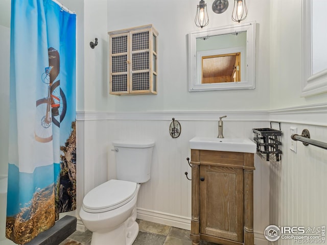 bathroom with walk in shower, vanity, and toilet