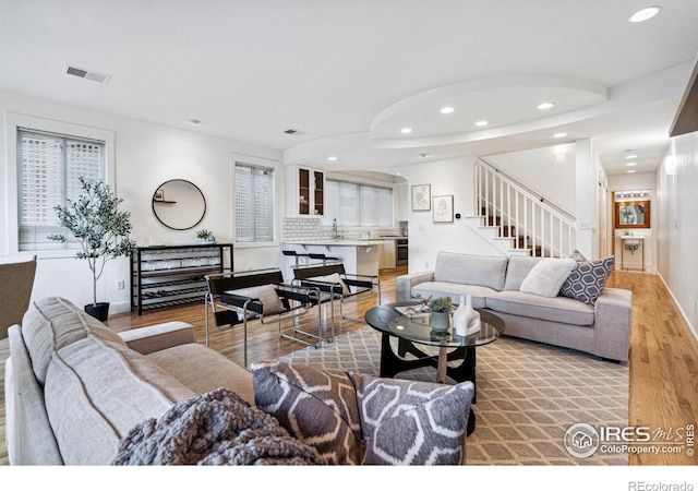 living room featuring sink and light hardwood / wood-style flooring