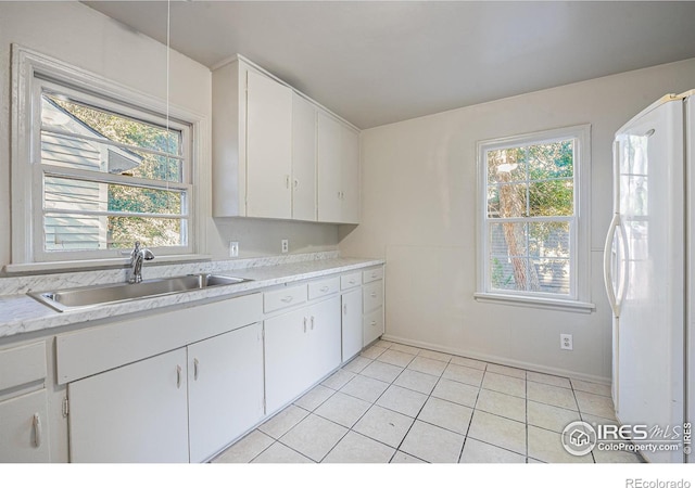 kitchen featuring a wealth of natural light, white cabinetry, and white refrigerator