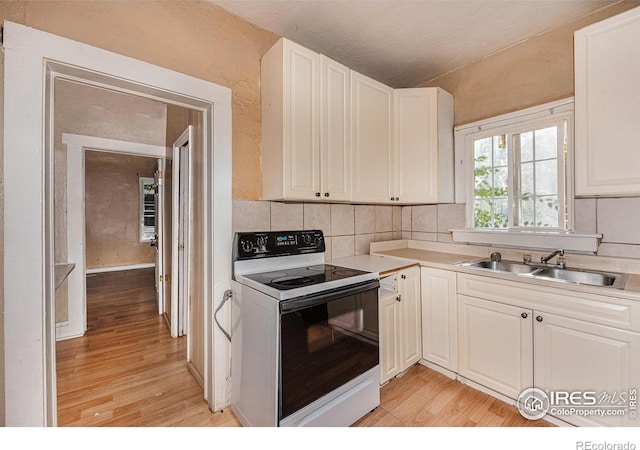 kitchen featuring sink, white cabinets, light hardwood / wood-style floors, and white electric range