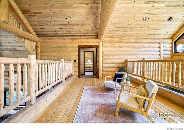 living area with log walls, wood-type flooring, vaulted ceiling with beams, and wooden ceiling