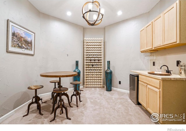 kitchen with pendant lighting, light colored carpet, sink, and light brown cabinetry