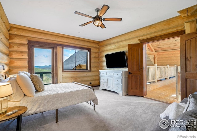 carpeted bedroom with ceiling fan and log walls