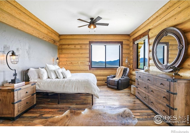 bedroom with access to outside, ceiling fan, dark hardwood / wood-style flooring, and log walls