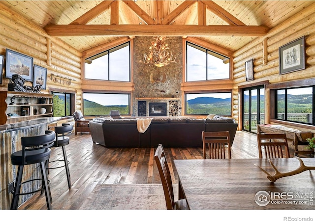 dining space featuring beam ceiling, a mountain view, high vaulted ceiling, and dark wood-type flooring