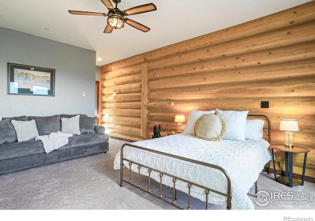 bedroom with carpet, ceiling fan, and rustic walls