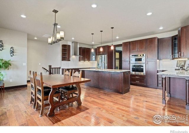 dining room with light hardwood / wood-style floors and a notable chandelier