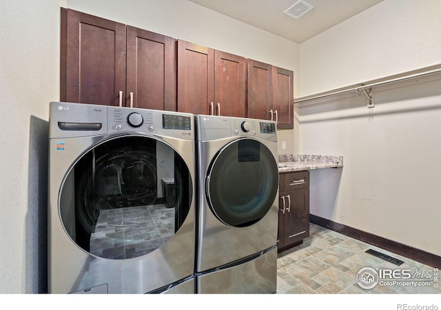 clothes washing area featuring cabinets and independent washer and dryer