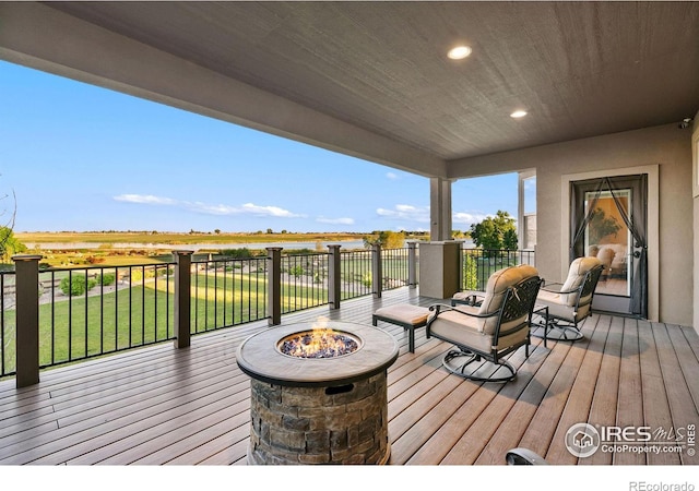 deck with a rural view and a fire pit