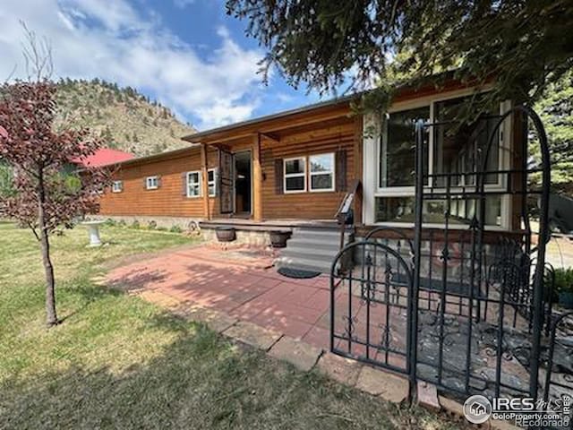 rear view of property featuring a patio area and a yard