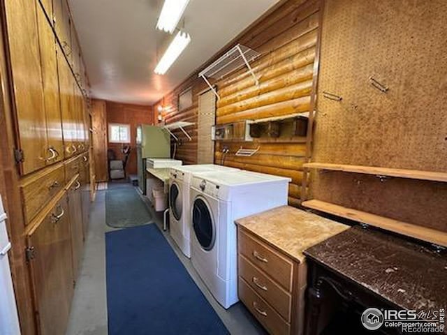 clothes washing area featuring washer and dryer and rustic walls