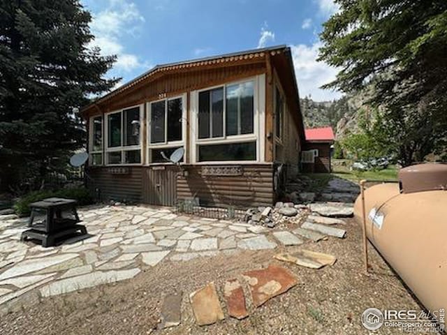 rear view of house featuring a fire pit and a patio area